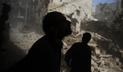 Civilians survey damage after an air strike in Douma, Syria. (Abd Doumany/AFP/Getty) Read more at: http://www.nationalreview.com/article/425107/why-iran-deal-ensures-war?target=author&tid=900280