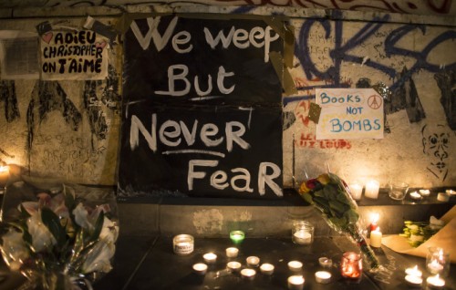 epa05025424 People place flowers and light candles in tribute for the victims of the 13 November Paris attacks at the foot of the statue on Place de la Republique in Paris, France, 14 November 2015. At least 120 people have been killed in a series of attacks in Paris on 13 November, according to French officials. EPA/IAN LANGSDON